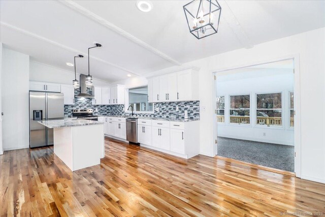 25 Jefferson Dr, New Milford, CT 06776 - kitchen with tasteful backsplash, vaulted ceiling, white cabinetry, wall chimney range hood, and appliances with stainless steel finishes