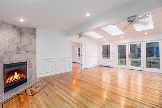 25 Jefferson Dr, New Milford, CT 06776 - unfurnished living room with recessed lighting, a tiled fireplace, a skylight, light wood-style flooring, and ceiling fan