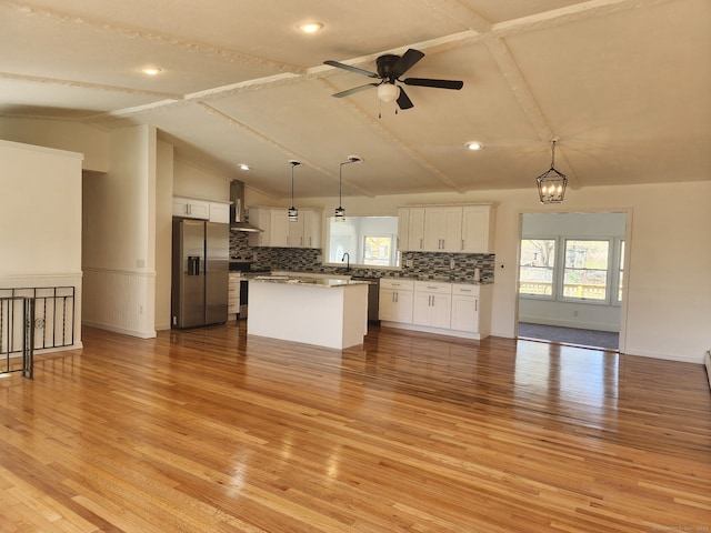 25 Jefferson Dr, New Milford, CT 06776 - kitchen with open floor plan, vaulted ceiling with beams, stainless steel appliances, white cabinets, and wall chimney exhaust hood