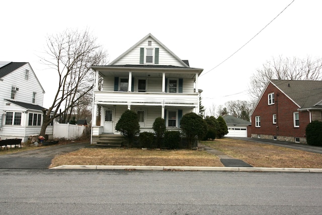 view of front of home with a porch, a balcony, and an outbuilding