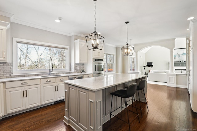 250 Valley Stream Ln, Southbury, CT 06488 - kitchen with a sink, appliances with stainless steel finishes, decorative backsplash, a kitchen island, and dark wood-style flooring