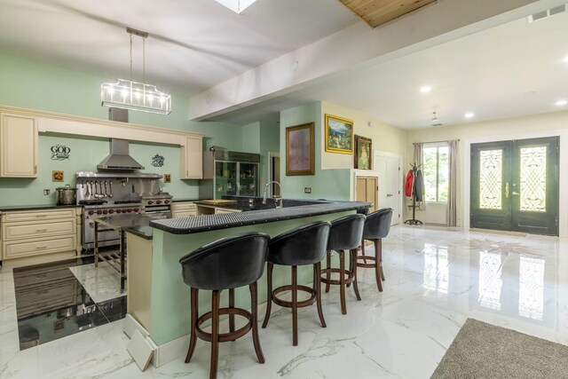 8 Tom Rd, East Haddam, CT 06423 - kitchen with cream cabinets, dark countertops, wall chimney exhaust hood, stainless steel range, and a breakfast bar area