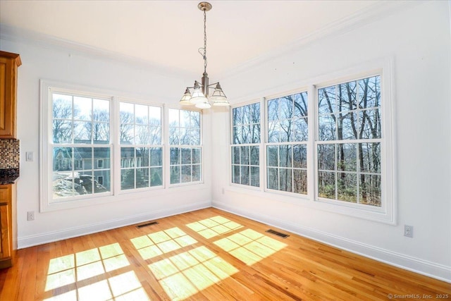 unfurnished sunroom with visible vents and an inviting chandelier