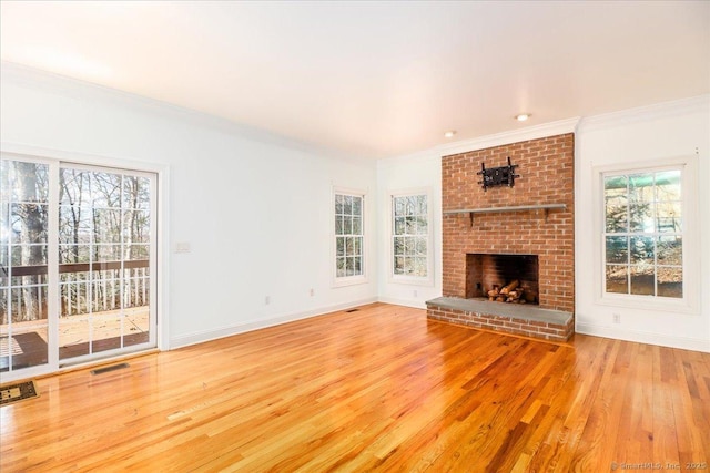 unfurnished living room with visible vents, baseboards, wood finished floors, and crown molding