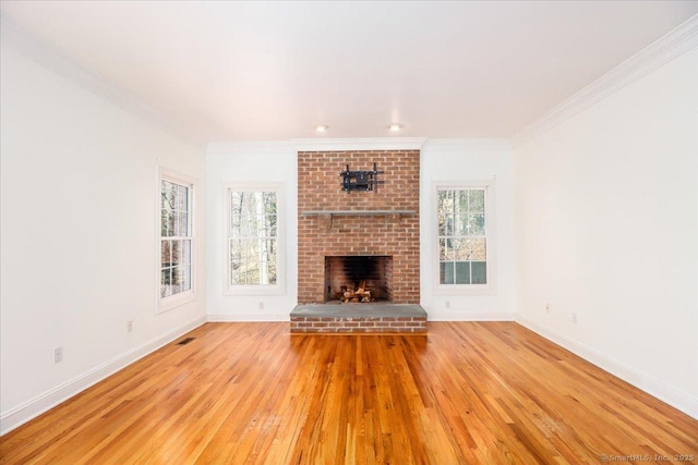 unfurnished living room with crown molding, a healthy amount of sunlight, and light wood finished floors
