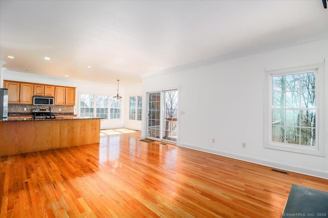 kitchen with visible vents, light wood-style flooring, appliances with stainless steel finishes, tasteful backsplash, and open floor plan