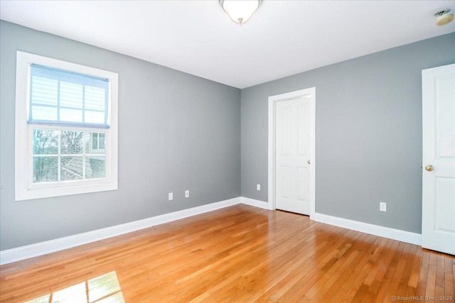empty room with baseboards and light wood-style flooring