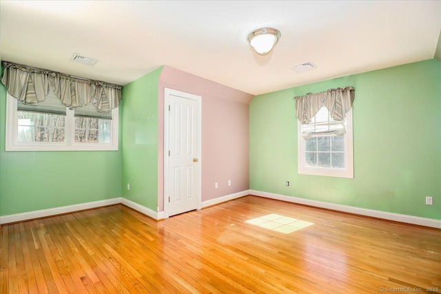 unfurnished bedroom featuring visible vents, baseboards, and hardwood / wood-style floors