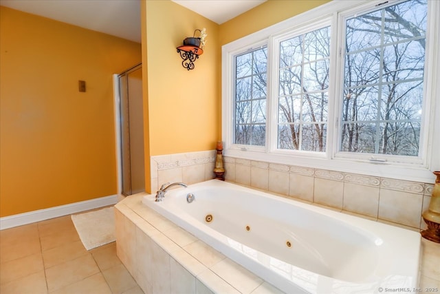 bathroom featuring baseboards, a tub with jets, a shower stall, and tile patterned flooring