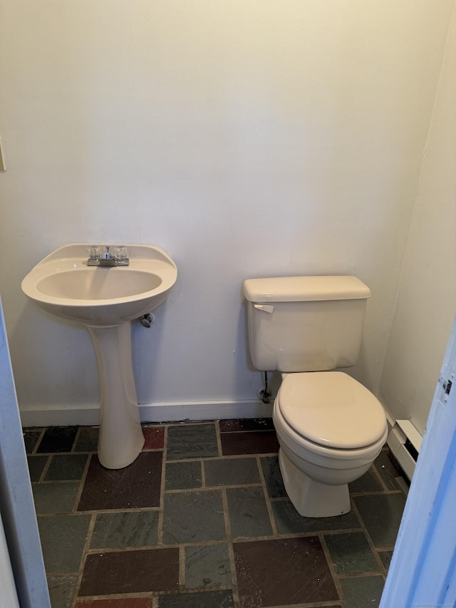 19 Huntington Rd, Scotland, CT 06264 - bathroom with toilet, a baseboard heating unit, stone tile floors, and baseboards