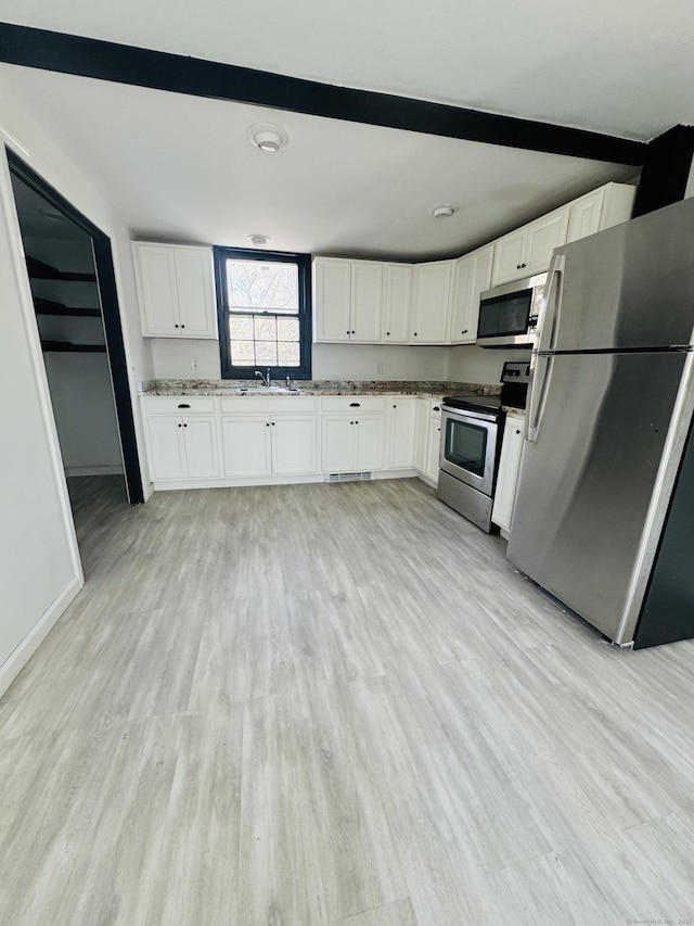 19 Huntington Rd, Scotland, CT 06264 - kitchen featuring stainless steel appliances, a sink, white cabinetry, light wood-style flooring, and beam ceiling