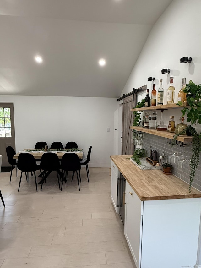8 Hubbard Rd, North Branford, CT 06471 - kitchen featuring butcher block countertops, white cabinets, vaulted ceiling, backsplash, and a barn door
