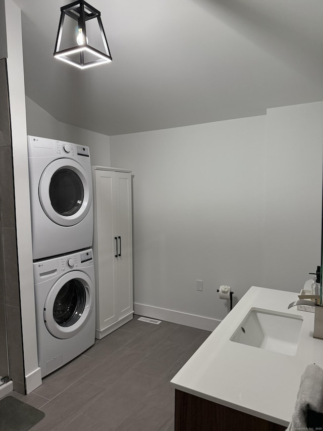 8 Hubbard Rd, North Branford, CT 06471 - laundry area with estacked washer and dryer, baseboards, and dark tile patterned flooring