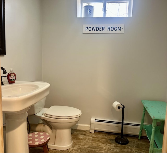 bathroom featuring a baseboard radiator, baseboards, toilet, and wood finished floors