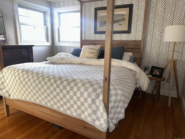 bedroom with wallpapered walls and wood finished floors