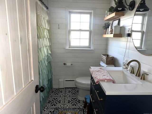 bathroom featuring vanity, toilet, baseboard heating, and wood walls