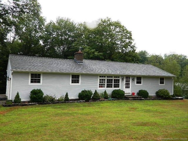 view of front of property featuring a chimney and a front yard