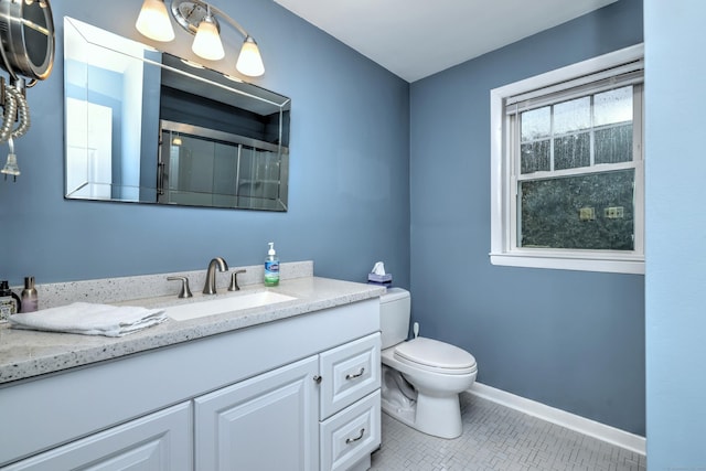 bathroom with a shower, toilet, vanity, tile patterned flooring, and baseboards
