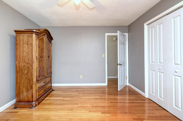 unfurnished bedroom with baseboards, a closet, and light wood-type flooring