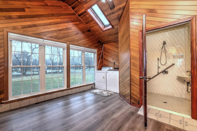 washroom with wooden ceiling, wood finished floors, a skylight, laundry area, and washer and dryer