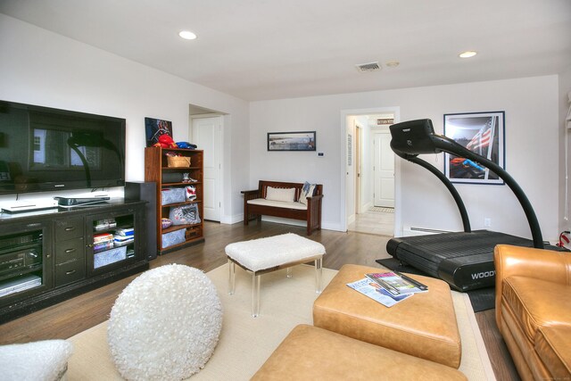 living room with wood finished floors, visible vents, and recessed lighting