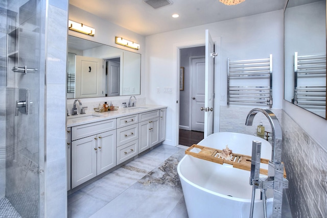 full bath with a sink, visible vents, double vanity, and radiator