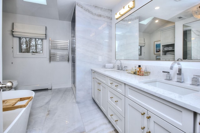 bathroom with double vanity, a baseboard heating unit, radiator heating unit, and a sink
