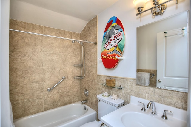 bathroom featuring toilet, a sink, shower / bathtub combination, and tile walls