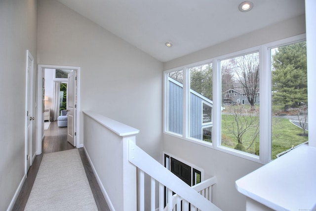 corridor with baseboards, an upstairs landing, and a wealth of natural light