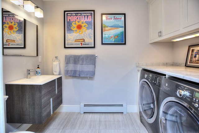 washroom featuring baseboards, a sink, independent washer and dryer, cabinet space, and a baseboard heating unit