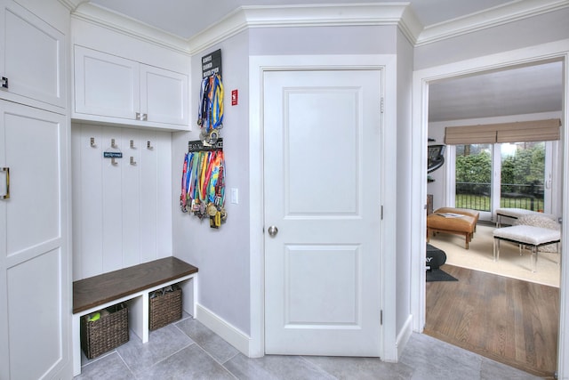 mudroom featuring light tile patterned floors, baseboards, and crown molding
