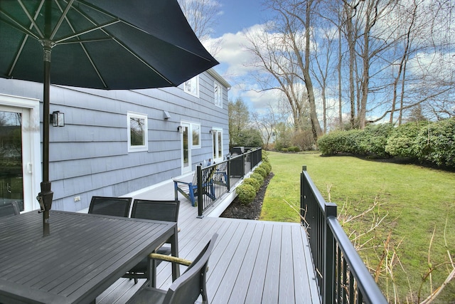 wooden deck with a yard and outdoor dining space