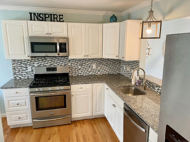 kitchen featuring white cabinetry, light wood-type flooring, appliances with stainless steel finishes, and a sink