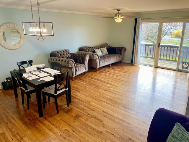 dining space featuring crown molding, light wood finished floors, baseboards, and ceiling fan with notable chandelier
