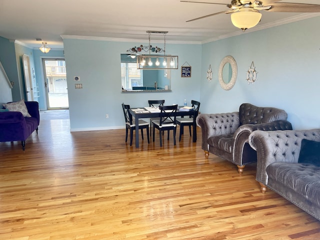 living room with baseboards, ornamental molding, a ceiling fan, and light wood finished floors