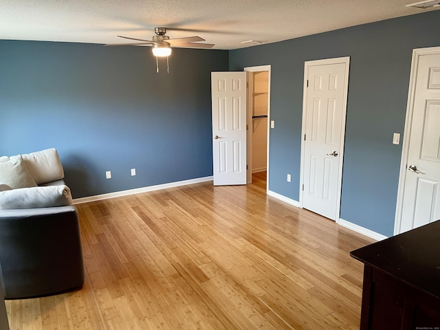 unfurnished room with light wood-style floors, ceiling fan, and baseboards