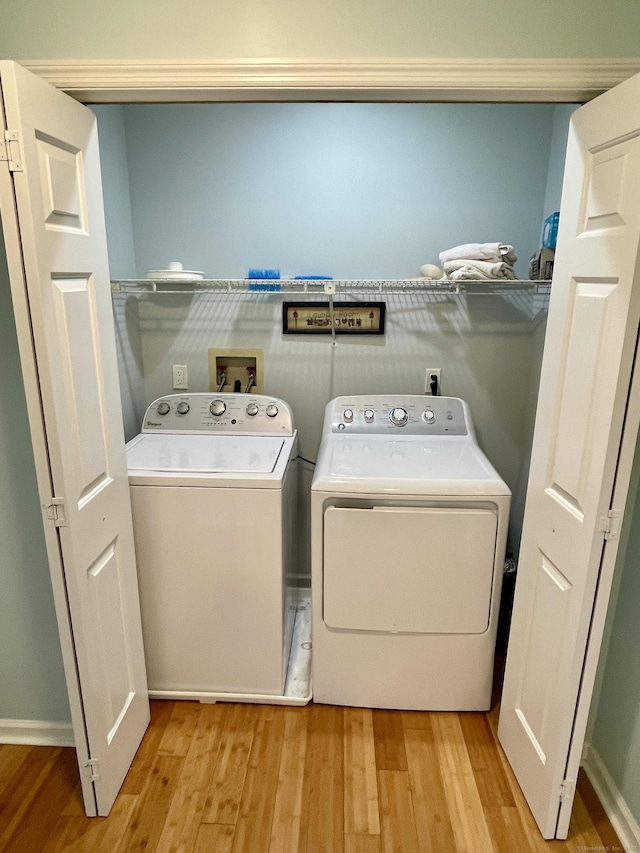 laundry room featuring independent washer and dryer, laundry area, and light wood-type flooring