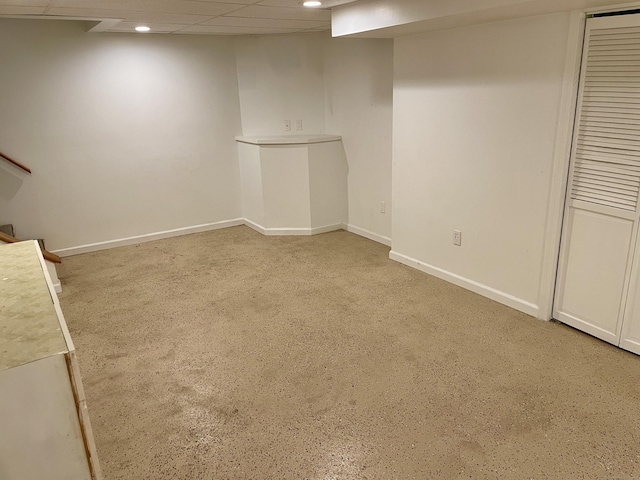 finished basement with recessed lighting, a paneled ceiling, stairway, and baseboards