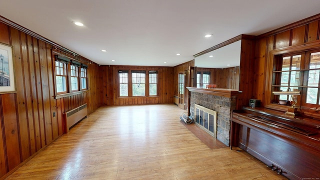 85 Hillcrest Ter, Meriden, CT 06450 - unfurnished living room featuring radiator, light wood-style flooring, a stone fireplace, wooden walls, and recessed lighting