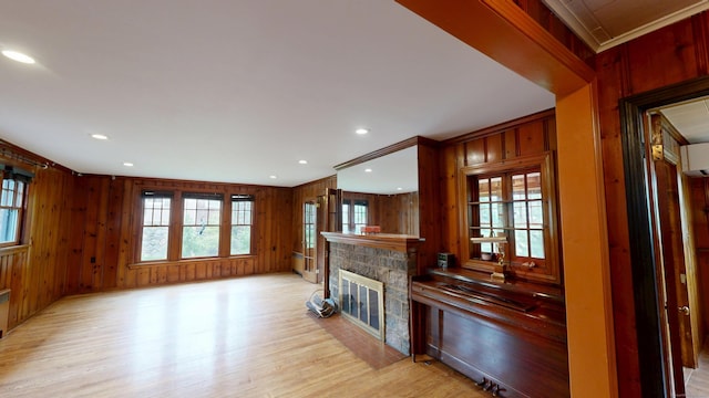 85 Hillcrest Ter, Meriden, CT 06450 - unfurnished living room with healthy amount of natural light, light wood-type flooring, a stone fireplace, wood walls, and recessed lighting