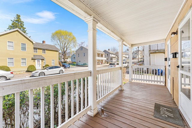 wooden deck with a residential view and covered porch