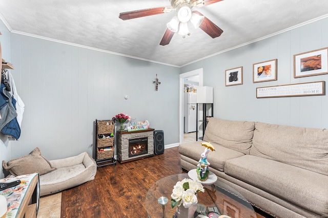 living area with ceiling fan, ornamental molding, and wood finished floors