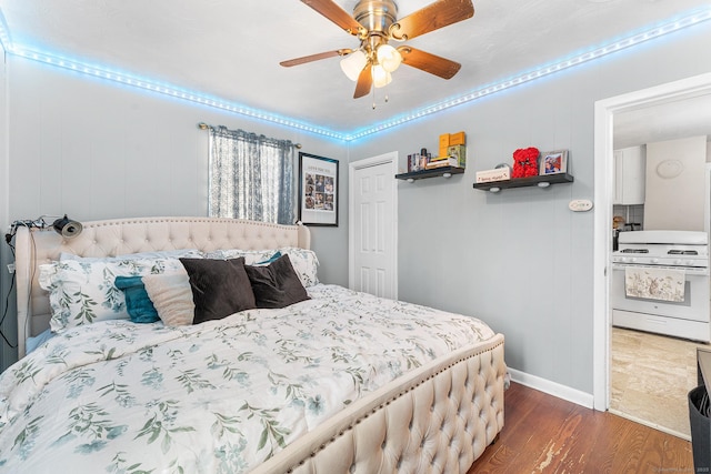 bedroom featuring dark wood-style flooring, a closet, ceiling fan, and baseboards