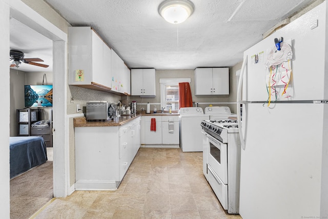 kitchen featuring white cabinets, washer and dryer, ceiling fan, white appliances, and a textured ceiling