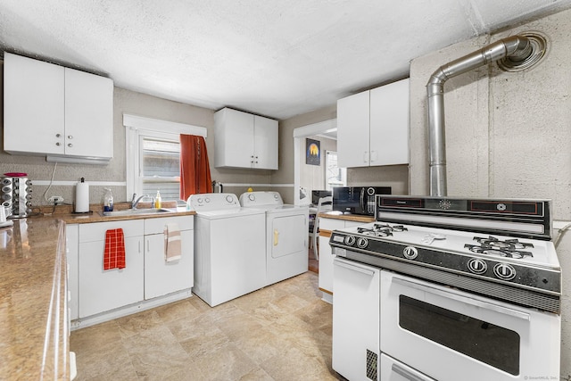 kitchen with separate washer and dryer, a sink, white gas stove, and a wealth of natural light