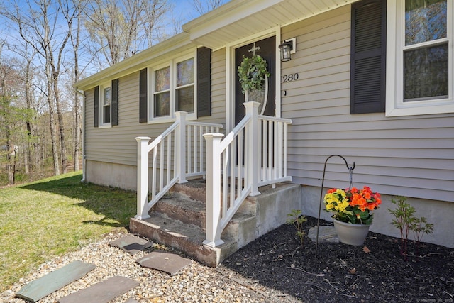 property entrance featuring a lawn