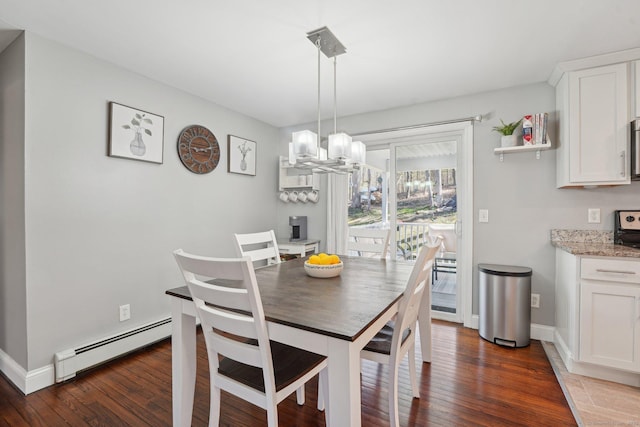 dining area with a baseboard heating unit, hardwood / wood-style flooring, a chandelier, and baseboards