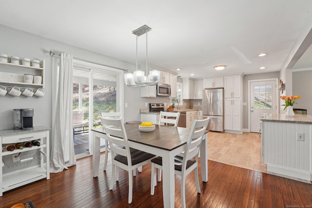 dining area with light wood finished floors and recessed lighting