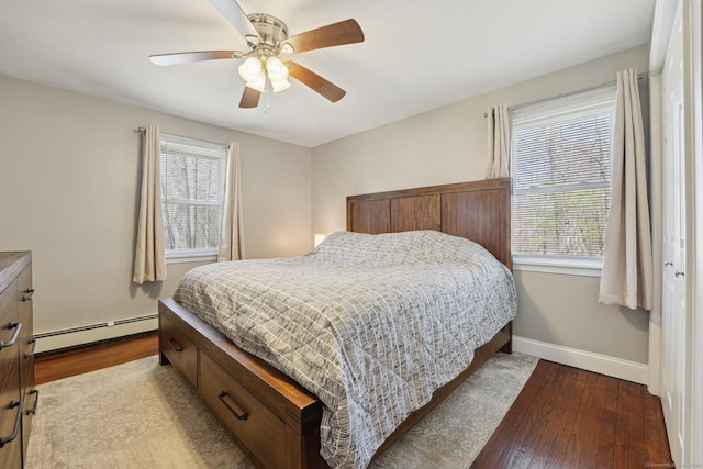 bedroom with a baseboard radiator, wood finished floors, baseboards, and a ceiling fan