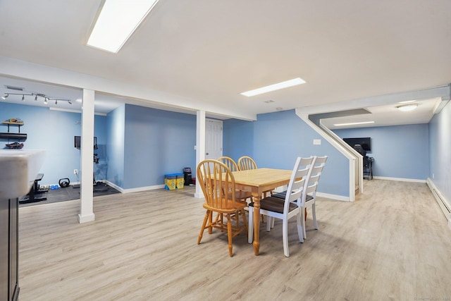 dining space featuring light wood finished floors and baseboards